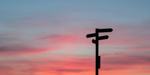 A signpost sillhouetted against an evening sky