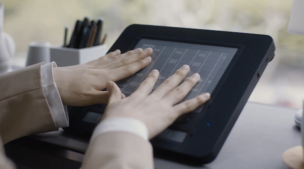 A pair of hands on top of the Dot Pad