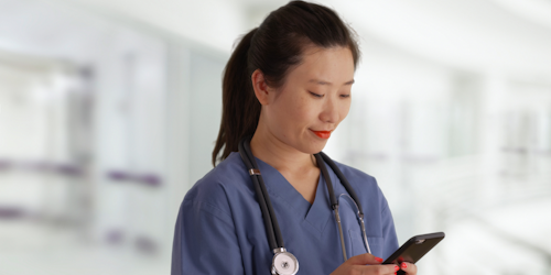 Woman wearing a medical mask looking at her cell phone